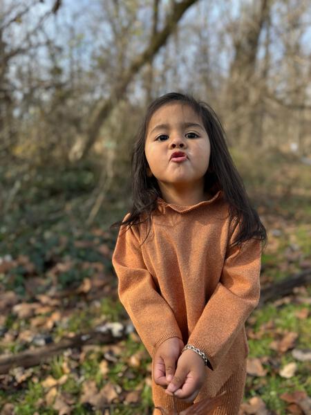 happy girl in autumn wood wearing gold cotton knit sweater with ruffle neck and matching leggings