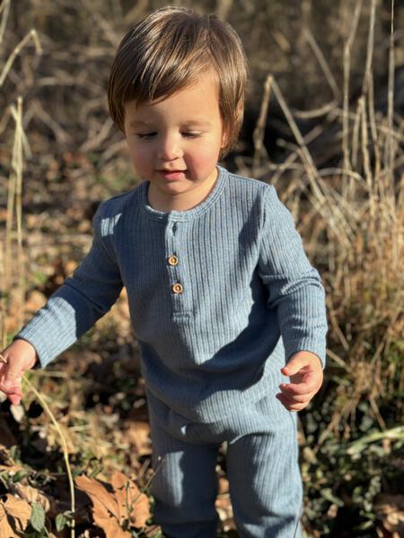 toddler in autumn sunshine wearing blue ribbed jersey sweat pants 2 button detail on front and matching button front henley top