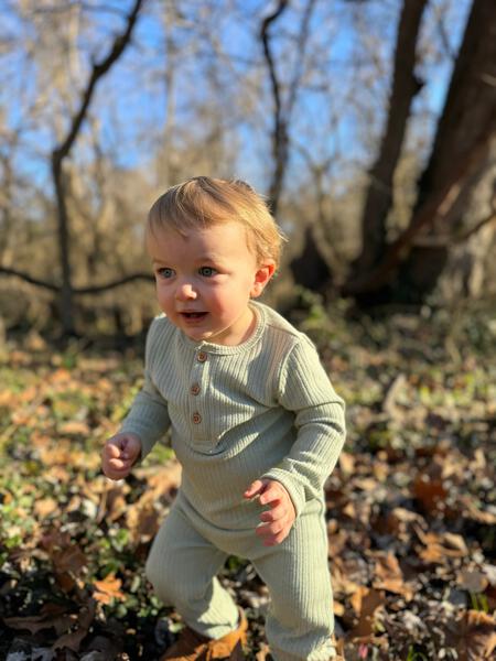 toddler in autumn sunshine wearing green ribbed jersey sweat pants 2 button detail on front and matching button front henley top