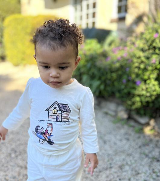 toddler in sunny garden wearing cream long sleeve tee with woodland animal print