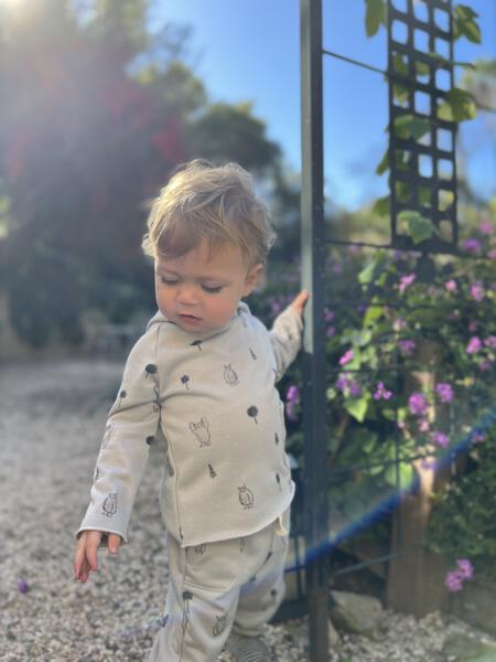 toddler in autumn sunshine wearing grey hooded sweat top with patch pocket and all over yeti print and matching sweat pants with side patch pockets