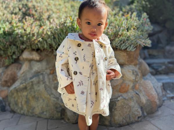 toddler in sunshine wearing cord jacket with double breasted buttons and peter pan collar cream floral print