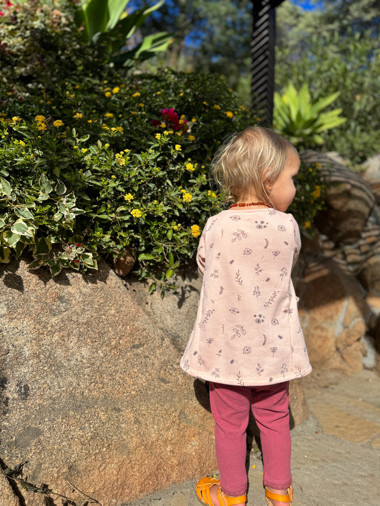 toddler in sunny garden wearing leggings in berry color with elasticated waist and ankle trim